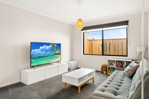 ein Wohnzimmer mit Fernseher und Sofa in der Unterkunft Kookaburra Corner in Cowes