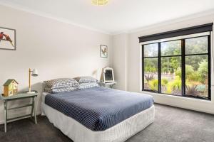 ein Schlafzimmer mit einem Bett und einem großen Fenster in der Unterkunft Kookaburra Corner in Cowes