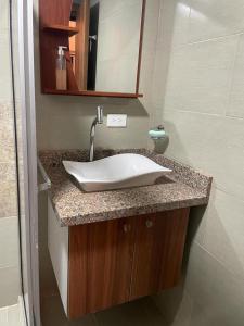 y baño con lavabo blanco y espejo. en Departamento en Esmeraldas, en Esmeraldas