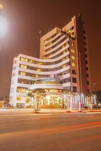 duży budynek w nocy z ulicą przed nim w obiekcie Muong Thanh Vinh Hotel w mieście Vinh