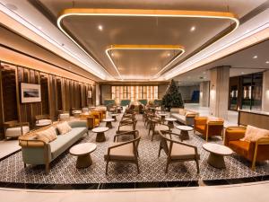 曼谷The Quarter Chaophraya by UHG的大堂配有沙发和桌子,还有圣诞树 更多142张照片