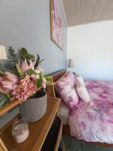 Un dormitorio con una cama y una mesa con flores. en Jardine Lodge - Can sleep 22!, en Corryong