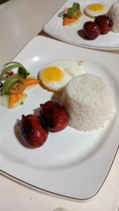 two plates of food on a white plate with rice at Grand Emilia Hotel in Cebu City
