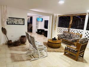 salon z krzesłami i kanapą w obiekcie El Faro Hostel w mieście Arboletes
