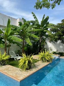 una piscina con palmeras y una silla junto a un edificio en Departamento en Esmeraldas en Esmeraldas