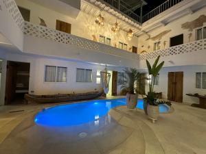 a large room with a large blue swimming pool at El Faro Hostel in Arboletes