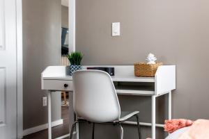 a white desk with a white chair in a room at Peaceful Oasis Condo, AC, Top Floor, Secure UG Parking, Balcony, King Bed! in Edmonton