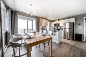 a kitchen and dining room with a table and chairs at Peaceful Oasis Condo, AC, Top Floor, Secure UG Parking, Balcony, King Bed! in Edmonton