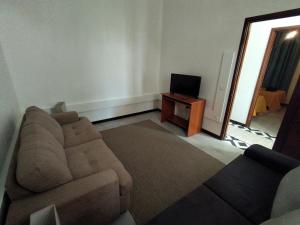 uma sala de estar com um sofá e uma televisão em Bus Stop House em Funchal