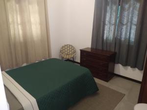 um quarto com uma cama, uma cadeira e uma cómoda em Bus Stop House em Funchal