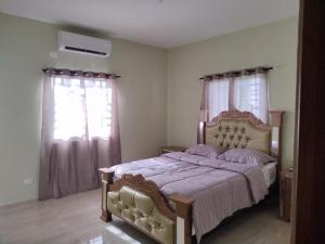 een slaapkamer met een groot bed en 2 ramen bij Cabrera Family Villa in Cabrera