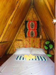 uma cama num quarto com telhado em SHALOM CAMP em El Nido