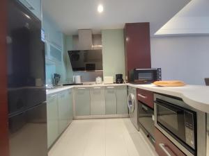 a kitchen with stainless steel cabinets and a microwave at Tianjin Crown International Apartment in Tianjin