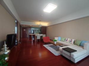 a living room with a couch and a table at Tianjin Crown International Apartment in Tianjin