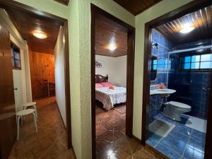 um quarto com uma casa de banho com uma cama e um chuveiro em Pousada Heron em Campos do Jordão