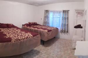 1 dormitorio con 2 camas y ventana en Casa Don Rubén, en Malinalco