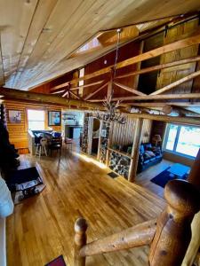 sala de estar con suelo de madera y comedor en Cozy log cottage en La Minerve
