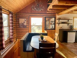 La Minerve的住宿－Cozy log cottage，小屋内带桌子的用餐室