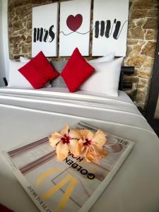 a bed with red pillows and a magazine on it at Romance in Ella in Ella