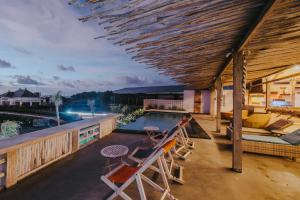 a patio with chairs and a swimming pool at Dream Beach Huts in Nusa Lembongan