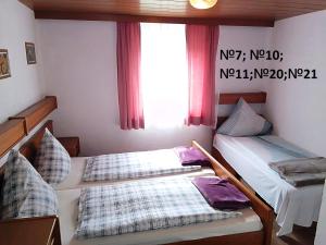 2 camas en una habitación con ventana en Pension Memminger, en Windorf