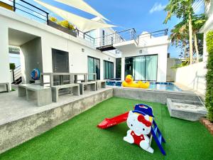 ein Haus mit einem Pool und einem Spielzeug auf dem Rasen in der Unterkunft Hua Hin Pool Villa Modern Cool - Fill Feel in Hua Hin