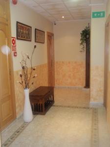 une chambre avec un vase et un banc dans l'établissement Hotel Beatriz, à Burriana