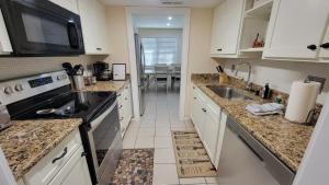 a kitchen with white cabinets and a sink and a microwave at HHI Homes LLC in Hilton Head Island