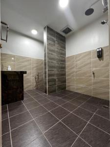 a bathroom with a shower and a tiled floor at Roomah Istana in Ipoh +7 photos