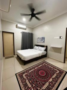 a bedroom with a bed with a ceiling fan and a rug at Roomah Istana in Ipoh