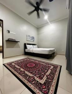 a bedroom with a bed with a rug and a ceiling fan at Roomah Istana in Ipoh