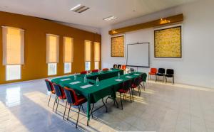 a conference room with a table and chairs and a screen at Hotel del Valle Inn in Pachuca de Soto