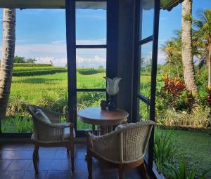 a room with a table and chairs and a view of a field at Sava Eco Retreat in Padangan
