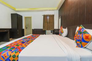 a bedroom with a large bed with a colorful blanket at FabHotel PS International in Lucknow