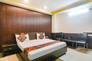 a bedroom with a bed and a table and chairs at FabHotel PS International in Lucknow +17 photos