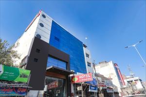 a tall building with blue windows on a city street at FabHotel PS International in Lucknow