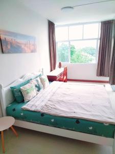 a large bed in a room with a window at Supanich condo opposite the Train Station ChiangMai in Chiang Mai