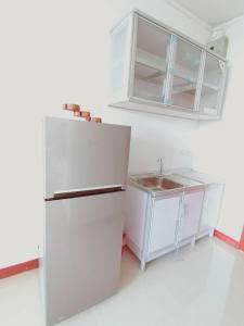 a kitchen with a refrigerator and a sink at Supanich condo opposite the Train Station ChiangMai in Chiang Mai