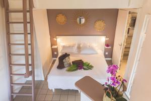ein Schlafzimmer mit einem Bett mit weißer Bettwäsche und Blumen darauf in der Unterkunft Ilet du Lagon in La Saline-Les-Bains