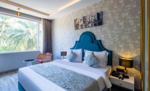 - une chambre avec un grand lit et une fenêtre dans l'établissement Renest Calangute Goa, à Calangute