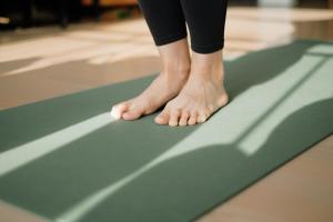 a person standing on a green yoga mat at Wayfinder Waikiki in Honolulu