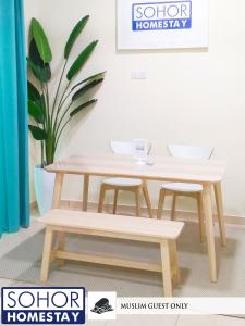 un tavolo in legno e 2 sgabelli in una stanza di Sohor Homestay Changlun a Changlun