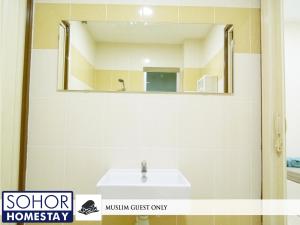 een badkamer met een wastafel en een spiegel bij Sohor Homestay Changlun in Changlun