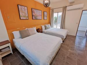 2 camas en una habitación con paredes de color naranja en Yilan Beitou NO.117 en Luodong