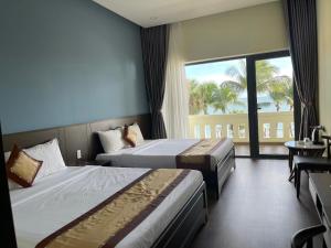 um quarto de hotel com duas camas e uma grande janela em Hon Rom 2 Resort em Mui Ne