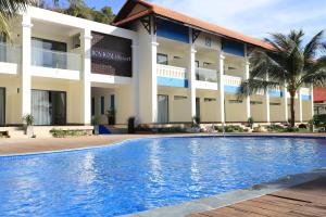 a hotel with a swimming pool in front of a building at Hon Rom 2 Resort in Mui Ne