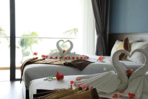 Hon Rom 2 Resort في موي ني: سريرين مع ديكورات بجعة في غرفة الفندق