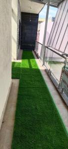 a hallway with green grass in a building at Kantesha Nest in Shimoga