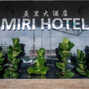ein Schild für ein Miami Hotel mit grünen Pflanzen in der Unterkunft Miri Hotel in Miri