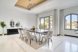 - une salle à manger avec une table et des chaises dans l'établissement Stella Stays Brilliant 4 BDR Palm Villa Beach Private Pool, à Dubaï